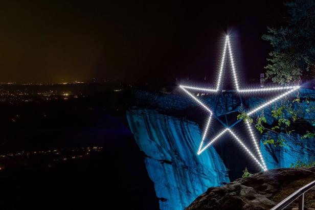 A lighted star display at night.