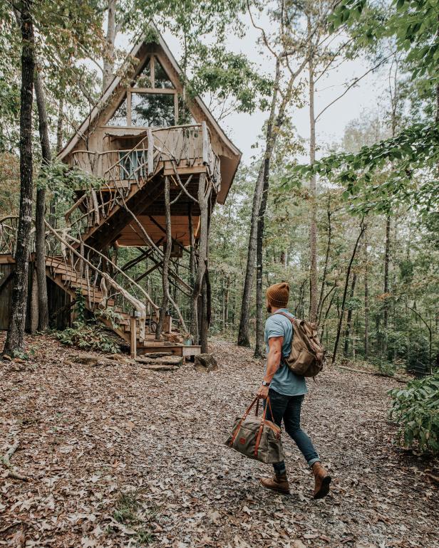 Man walking toward treehouse in Dahlonega, Georgia. Photo by @gcalebjones