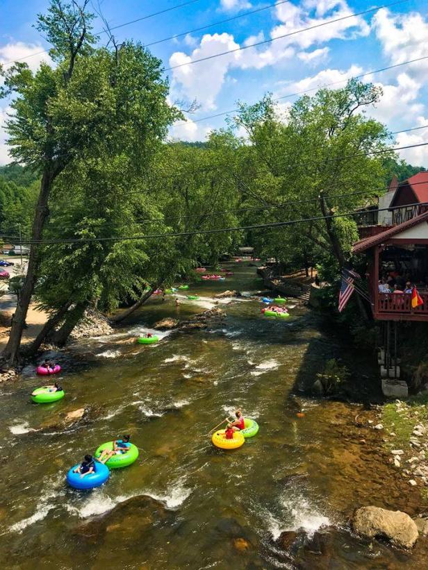Visitors float in tubes down a river