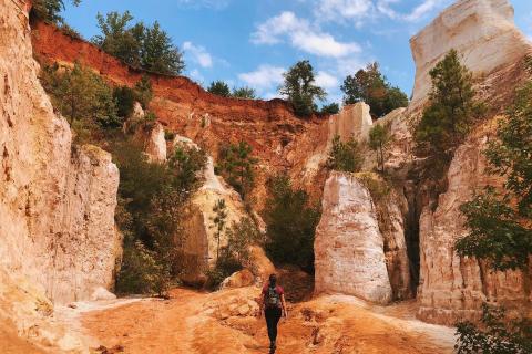 Hiker walking through a canyon surrounded by large rocks