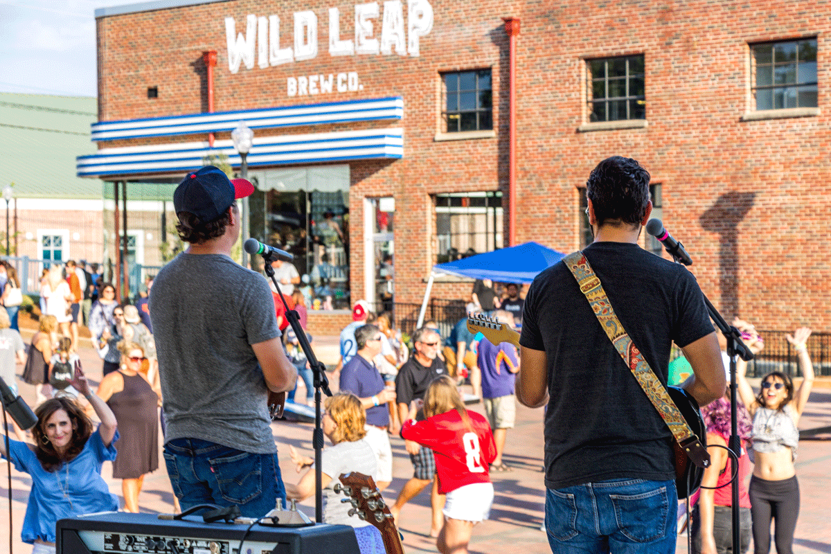 People dancing to outdoor live music at Wild Leap brewery in LaGrange, Georgia.