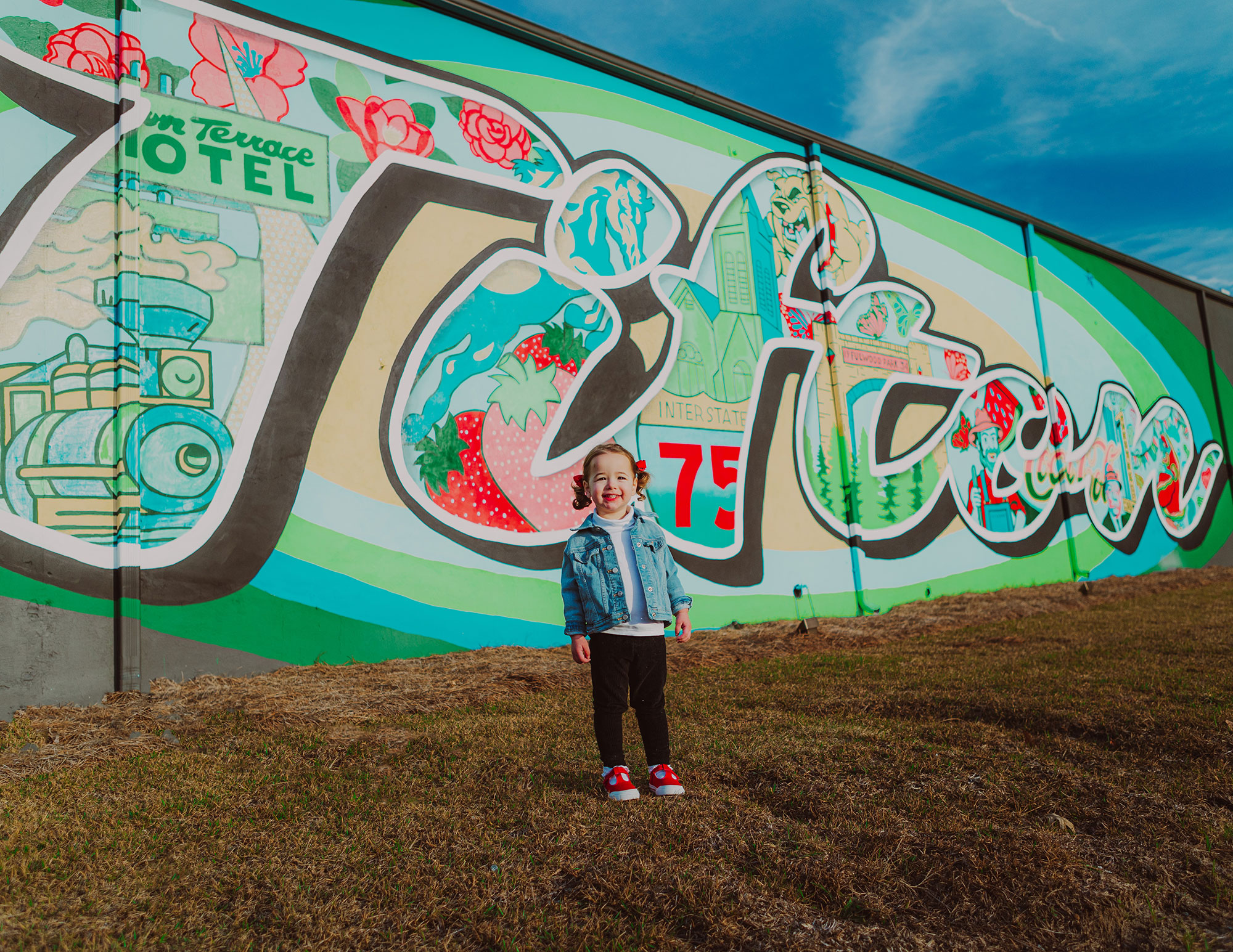 Young child standing in front of a mural in Tifton, Georgia
