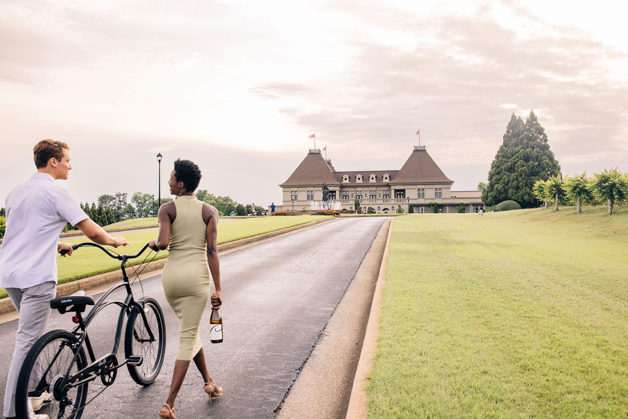 Couple walking a bike on a path toward Chateau Elan in Braselton, Georgia