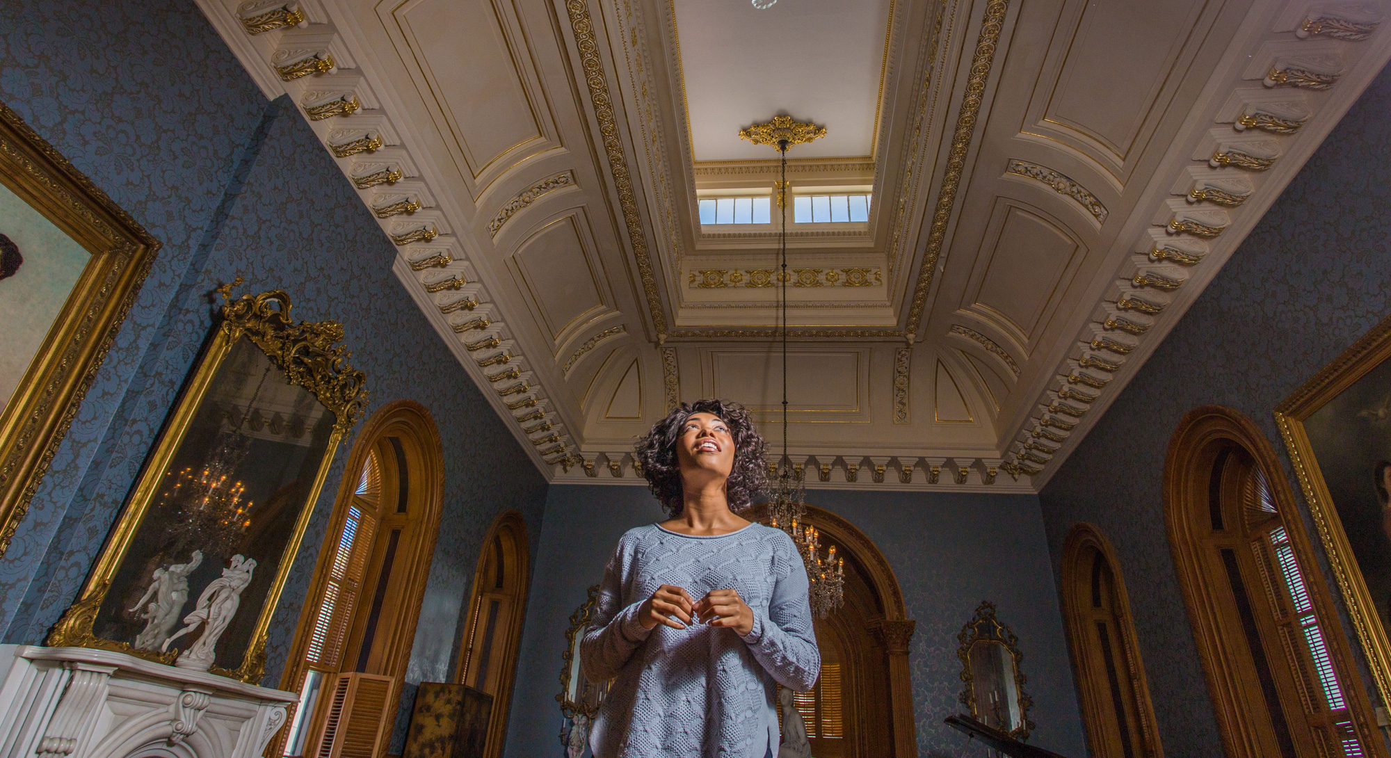 A woman gazes toward the ornate ceiling at the Hay House in Macon, Georgia