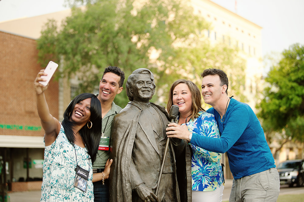 Group of people taking a selfie with the James Brown statue in Augusta, Georgia