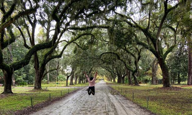 Woman jumping under the trees at Wormsloe State Historic Site in Savannah. Photo by @serend1p1tyy