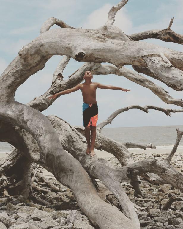 Boy on Driftwood Beach on Jekyll Island, Georgia. Photo by @qued3point14
