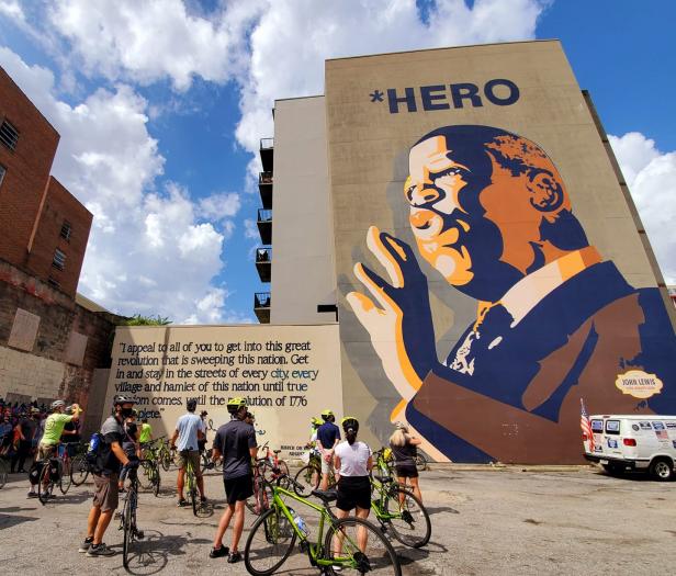 Bicyclists stopped at the John Lewis mural in Atlanta