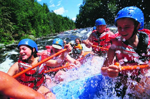 group of rafters in action doing down a river with water splashing
