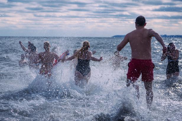 people in swimsuits run into the Ocean