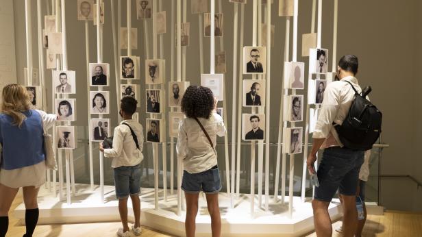 Four people looking at old black and white photographs inside the National Center for Civil and Human Rights in Atlanta, Georgia. Photo by @thecurlycoopers.