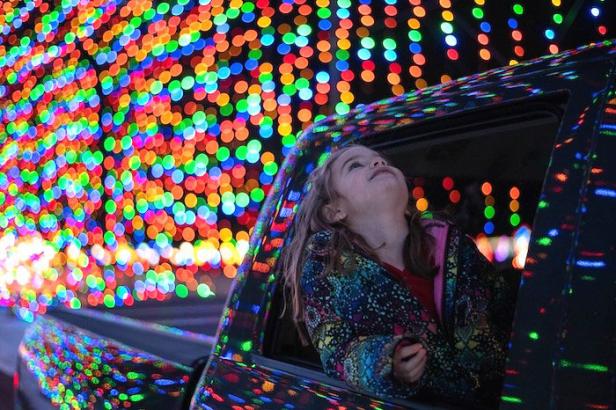 Child looking out of a truck window at a tunnel of lights
